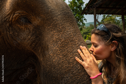 Canvas Print Kissing the elephant Girl Tourist kisses elephants trunk