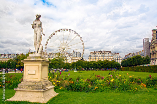 Marble statue and ferris wheel at Garden of Tuileries (Jardin des Tuileries) outside the Louvre in Paris, France