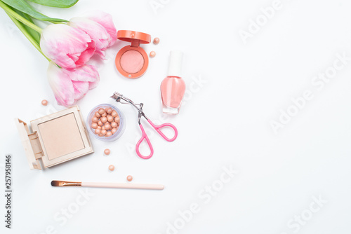  Cosmetics and pink tulips on white background