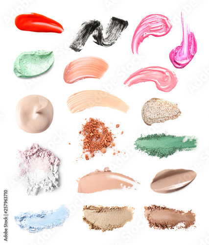Set with swatches of lipsticks, eye shadows, mascara and skin foundations on white background, top view
