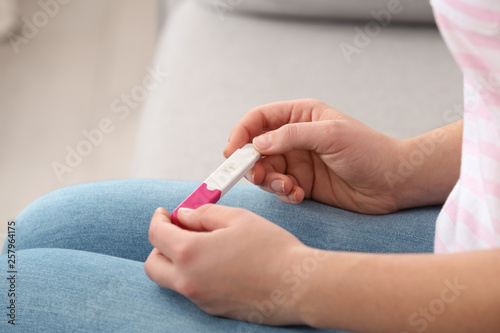 Young woman with pregnancy test indoors  closeup. Gynecology and childbirth