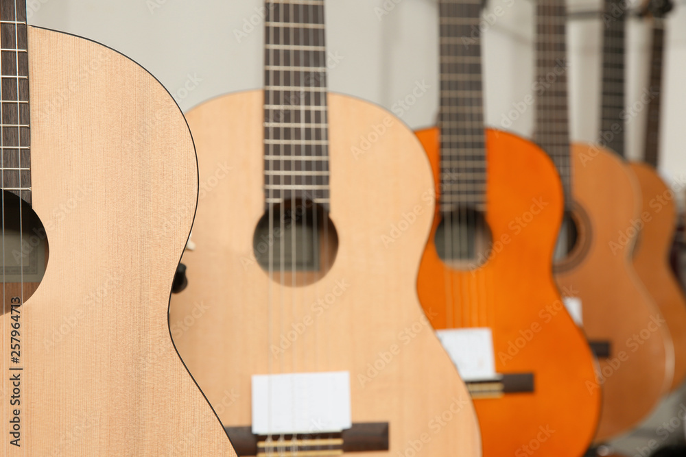 Obraz premium Modern wooden guitars in music store, closeup