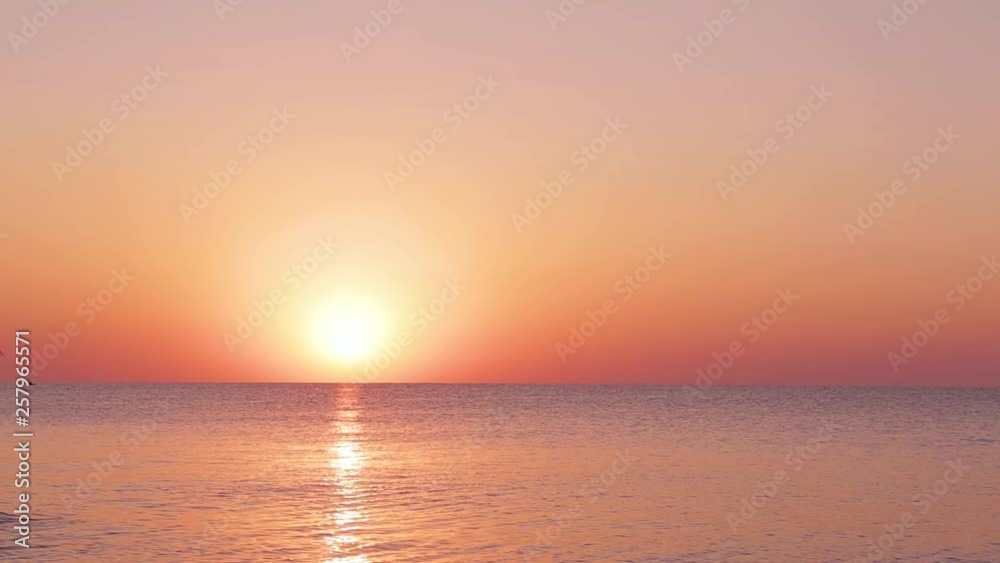 beautiful sunrise under the calm sea. the sun rises right from the sea and colors the sky with incredible colors. amazing morning at the seaside beautiful sunrise under the calm sea. the sun rises right from the sea and colors the sky with incredible colors. amazing morning at the seaside