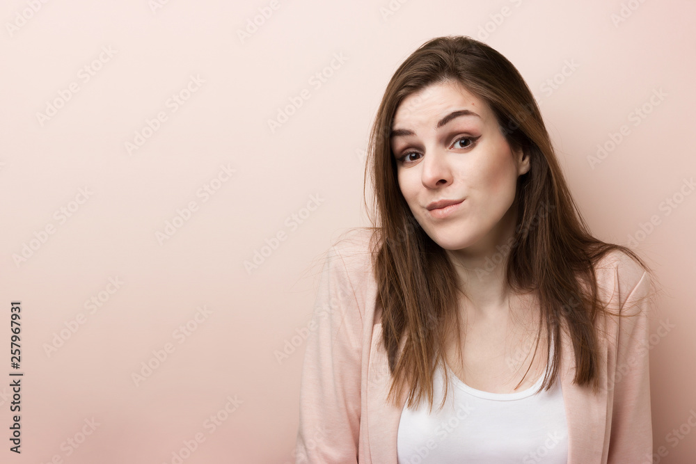 Portrait of a young surprised cute woman on a pink background Portrait of a young surprised cute woman on a pink background