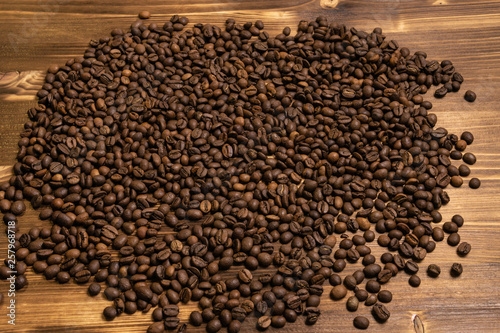 Roasted coffee beans in bulk on a wooden background © Albert Bugaev