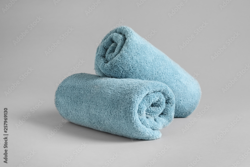 Fresh fluffy rolled towels on grey background Fresh fluffy rolled towels on grey background