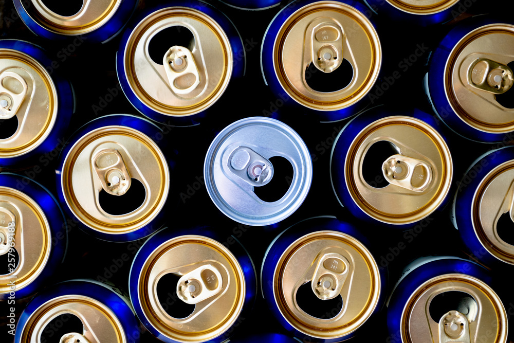 Abstract pattern of opened aluminium cans, top view. One white soda or beer can standing out among yellow and blue cans. Excess drinking, consumerism, alcoholism, or 'be different' concept. Abstract pattern of opened aluminium cans, top view. One white soda or beer can standing out among yellow and blue cans. Excess drinking, consumerism, alcoholism, or 'be different' concept.