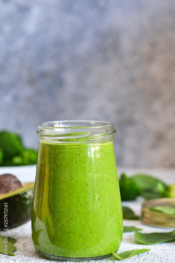 Green smoothie with spinach, avocado and broccoli on a concrete background. Green smoothie with spinach, avocado and broccoli on a concrete background.