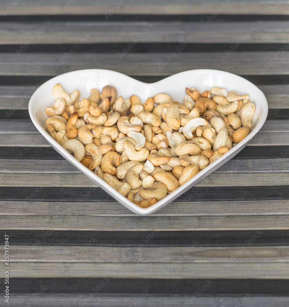 Nuts arranged in heart on background. Healthy Food image close up cashew nuts. Love Texture Nuts arranged in heart on background. Healthy Food image close up cashew nuts. Love Texture