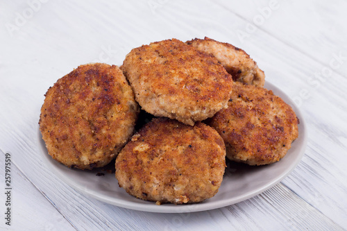 cutlets on a grey plate, on a white wooden background