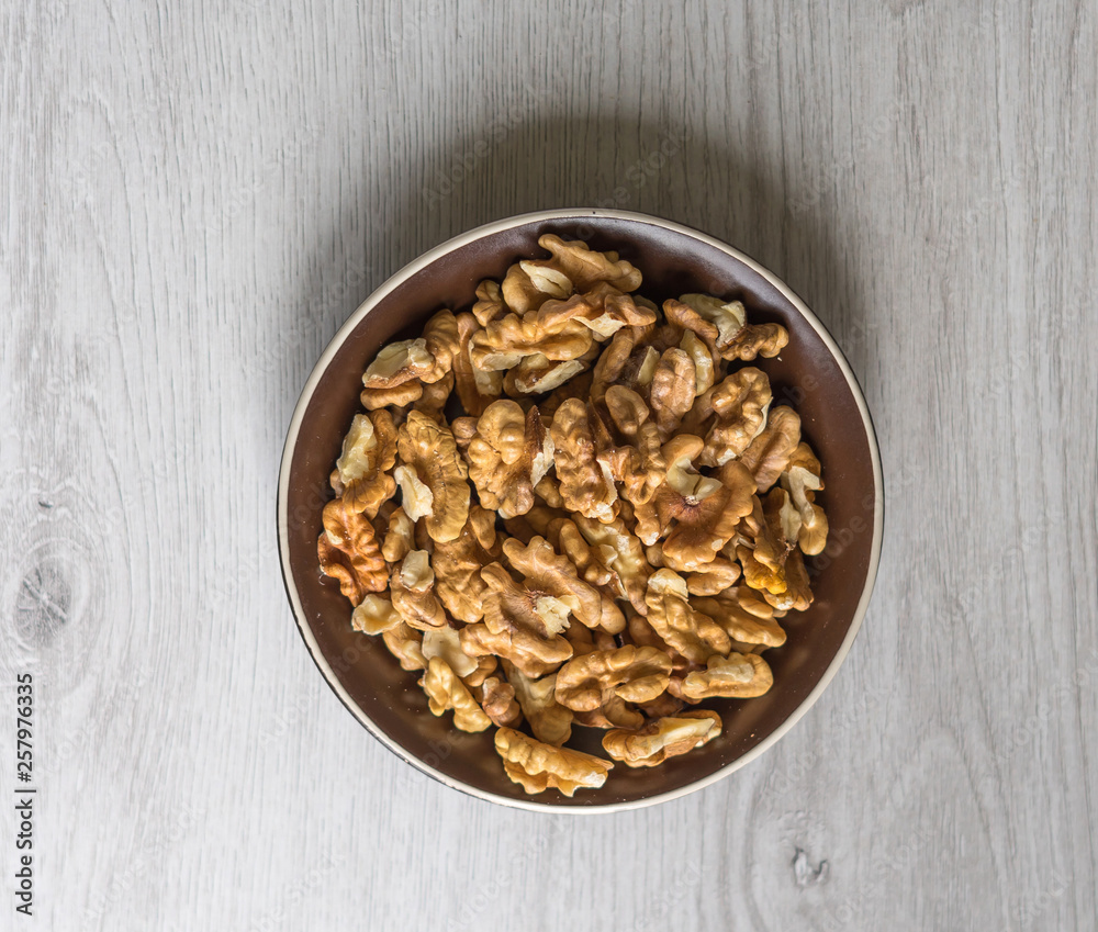 Healthy food for background image close up walnuts. Nuts texture on white grey table top view on the cup plate Healthy food for background image close up walnuts. Nuts texture on white grey table top view on the cup plate