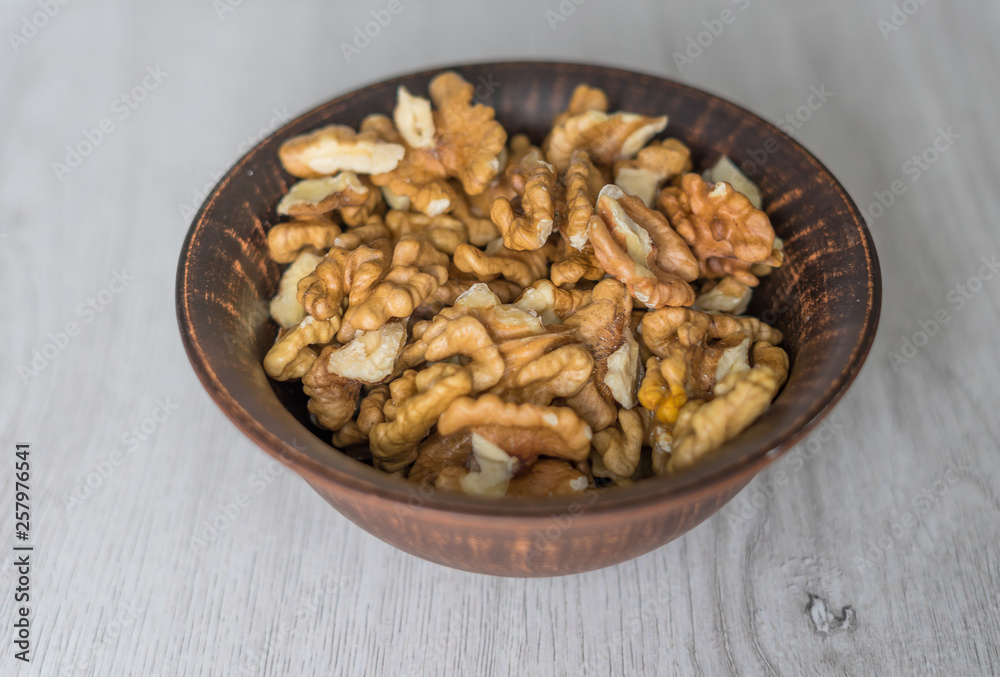Healthy food for background image close up walnuts. Nuts texture on white grey table top view on the cup plate Healthy food for background image close up walnuts. Nuts texture on white grey table top view on the cup plate