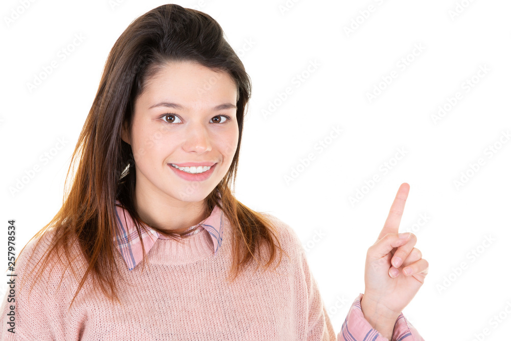 young woman smiilng pointing at copyspace looks in camera young woman smiilng pointing at copyspace looks in camera