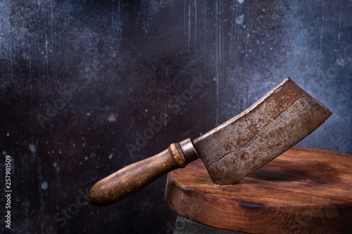 Quadro em tela Meat cleaver cut in round cutting board on grunge blue background with copy space