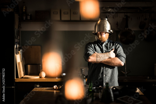 Man standing in kitchen, wearing colander as helmet photo