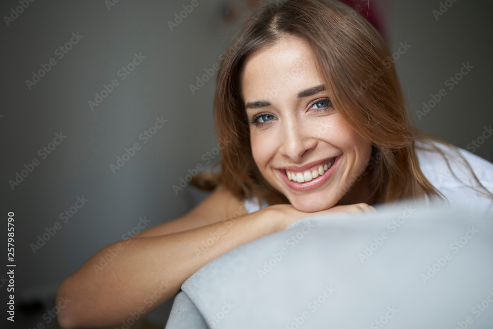 Portrait of happy young woman on couch
