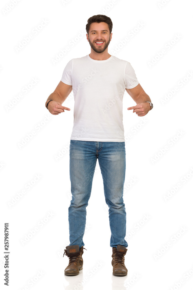 Happy Young Man In Jeans And White T-shirt Is Standing And Pointing At Himself