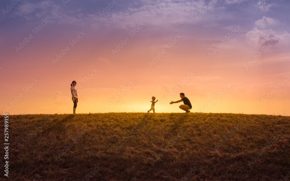 Happy family playing outdoors at sunset.