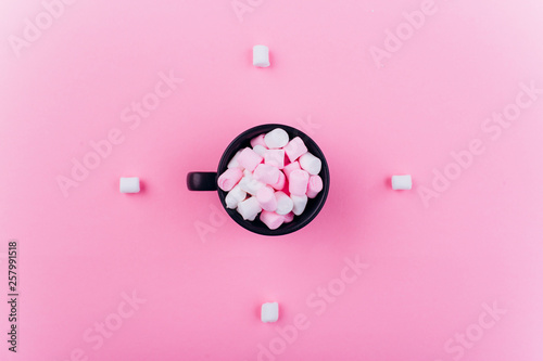 Pastel marshmallow in a cup on a pink background.