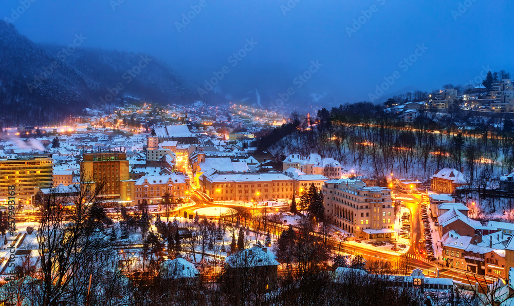 Aerial view of Brasov town, illuminated architecture of the city in winter season - Romania