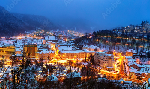 Aerial view of Brasov town, illuminated architecture of the city in winter season - Romania