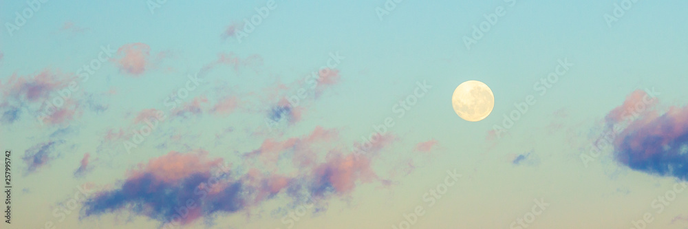 Dawn sunrise pink clouds in sky with full moon background. Beautiful skies. Sunset inspiring view and scenery. Heavenly sky. Ethereal fantasy background.