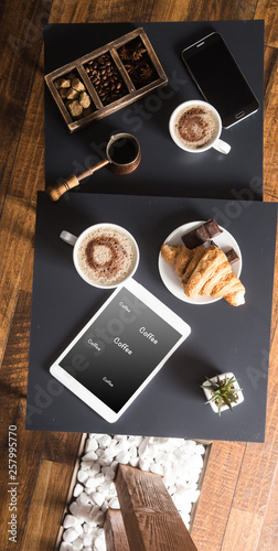 smart phone and Black fried coffee beans in cafe with cookie and cake on dark textured background