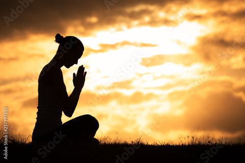 silhouette of praying woman