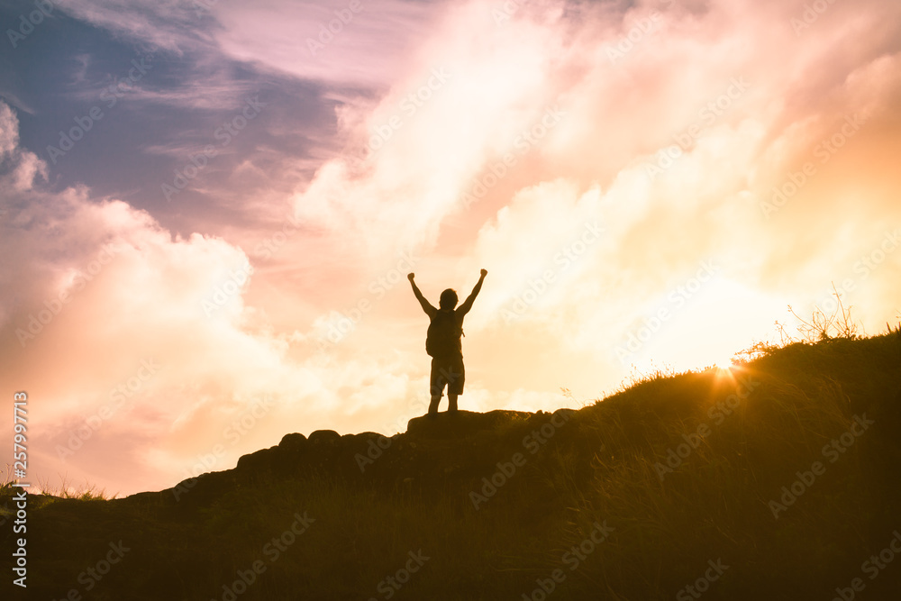 silhouette of man on top of mountain, life goals and having courage concept.  