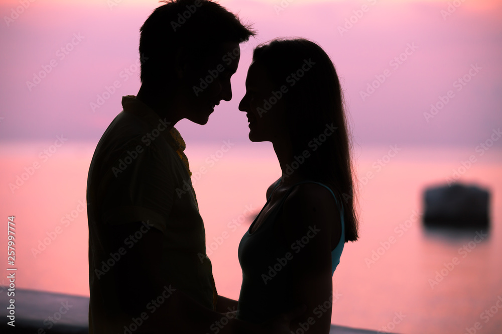 romantic setting of man and woman on the beach at sunset