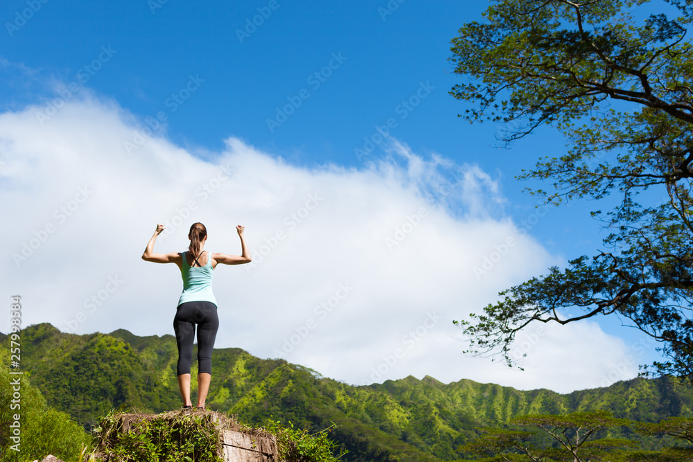strong young woman flexing on top of mountain strong young woman flexing on top of mountain