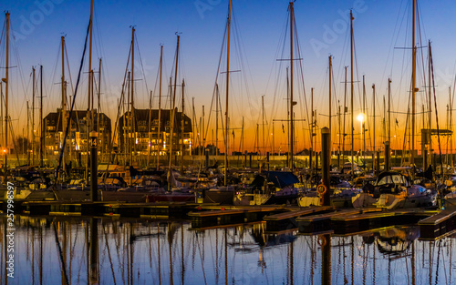 the port of Blankenberge at sunset, many docked boats, beautiful city scenery of a popular town in Belgium photo