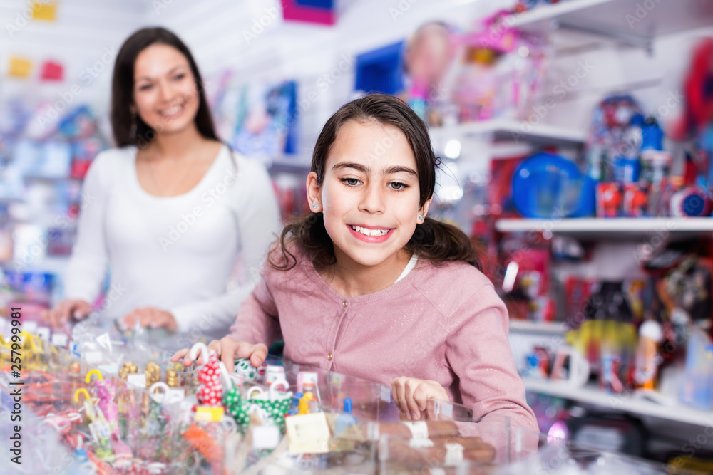 Fototapeta premium Woman with emotional daughter choosing candies in the candy shop