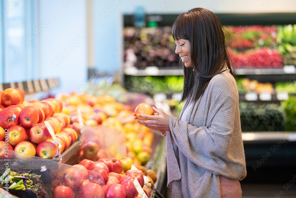 African American woman shopping for produce in grocery store African American woman shopping for produce in grocery store