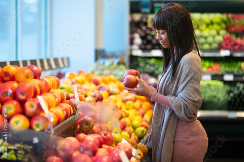 Tableau sur toile African American woman shopping for produce in grocery store