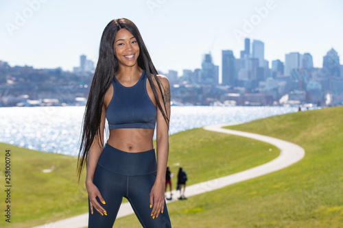 Obraz na plátně Beautiful woman with long black hair wearing yoga pants and sports bra outside d