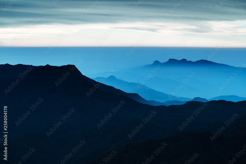 Blue landscape with mountains and morning fog. Cloudy sunrice