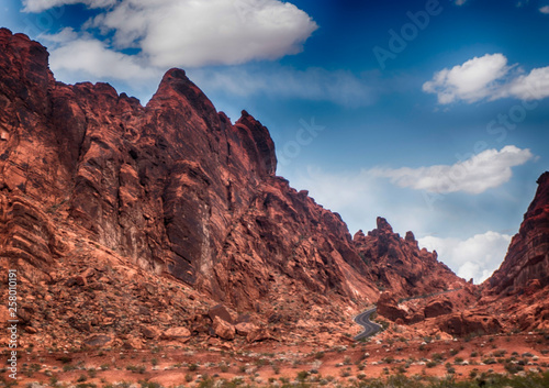 A small winding road travels through beautiful red rocks