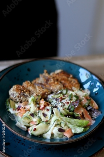 Fried chicken with sesame and zucchini and carrot salad with yoghurt sauce. Selective focus.