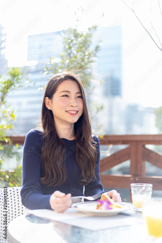 オープンテラスカフェで余暇を楽しみむ女性 オープンテラスカフェで余暇を楽しみむ女性