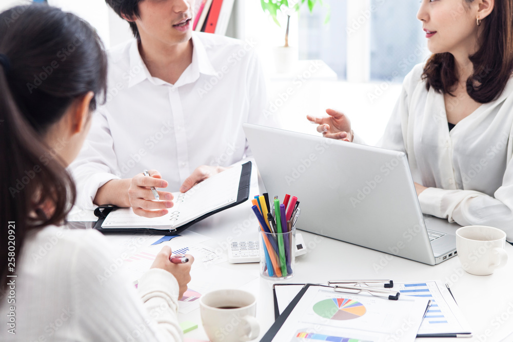 オフィスで打ち合わせをする若手社員たち オフィスで打ち合わせをする若手社員たち