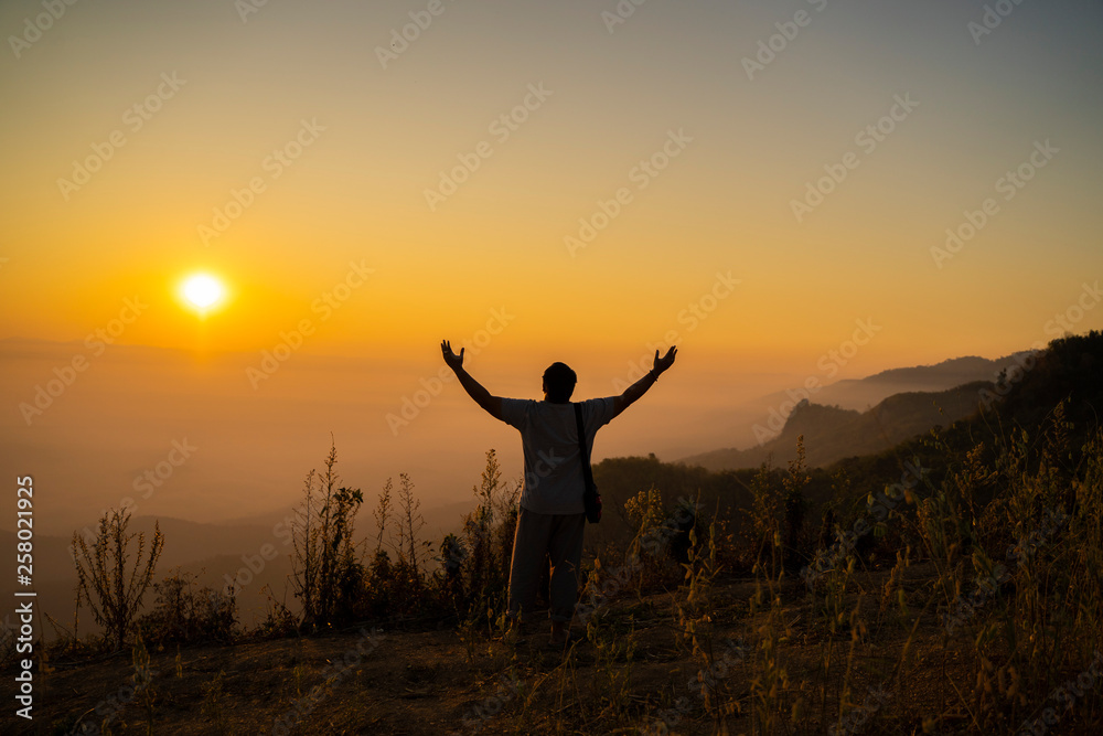 Men are happy with the top of the mountain. At sunrise Men are happy with the top of the mountain. At sunrise