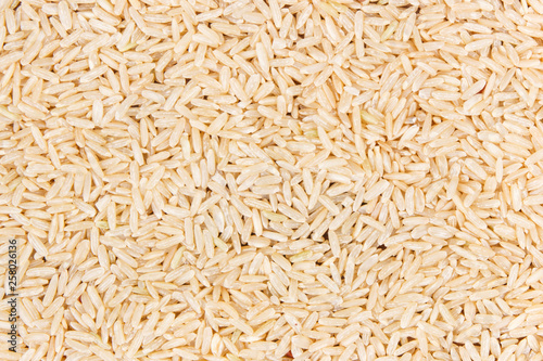Heap of brown rice as background, healthy, gluten free nutrition concept, copy space for text