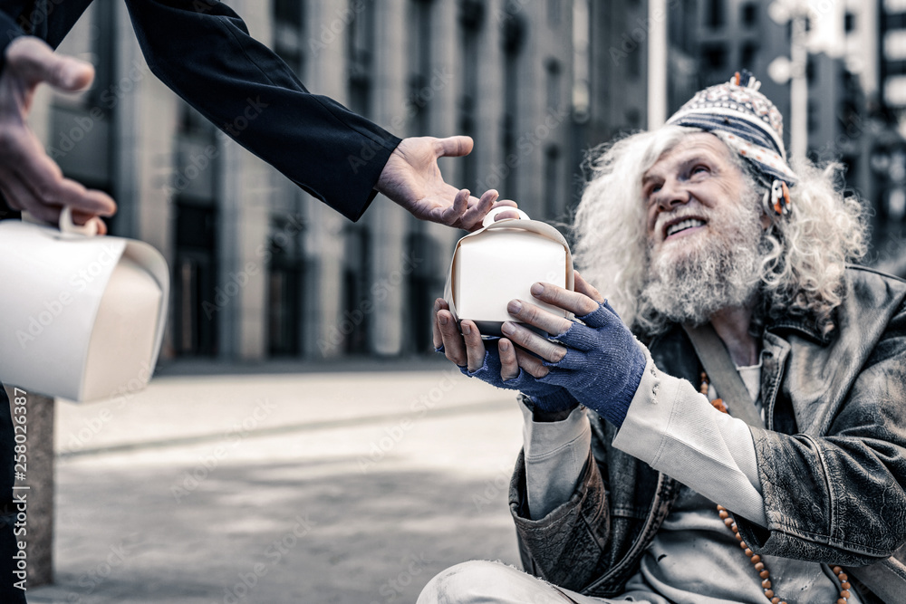 Φωτογραφία Cheerful long-haired poor man being excited while receiving box with food