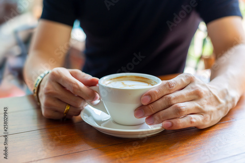 Hand holding hot coffee cup