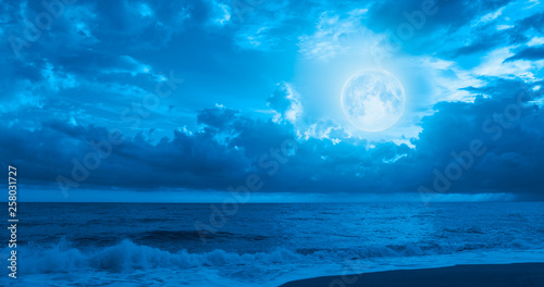 Night sky with moon in the clouds with dark sea "Elements of this image furnished by NASA