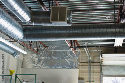 A view of the pipes and vent of the air ducts up in the garage rafters. 