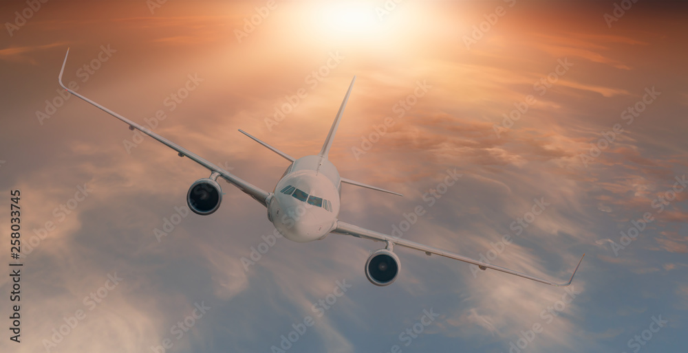 Fototapeta premium Biały samolot pasażerski w chmurach o zachodzie słońca - podróż transportem lotniczym