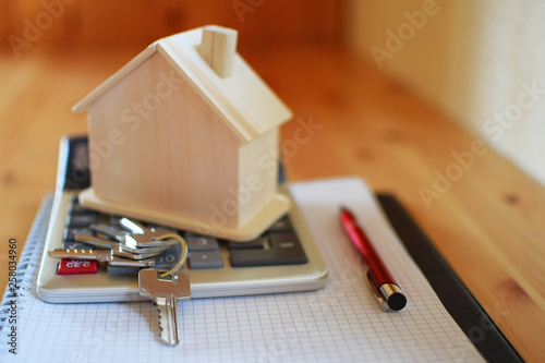 Wallpaper Mural Paper notebook with calculator, house model keys and pen on wooden table.  House building, buying or renting new home planning concept. Torontodigital.ca