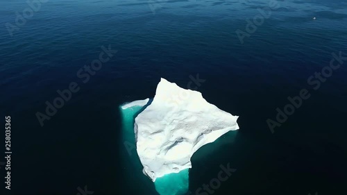 Beautiful aerial shot of an enormous ice berg 70 nautical miles off of the coast of Labrador. Ocean extending as far as the eye can see, pure bliss. photo